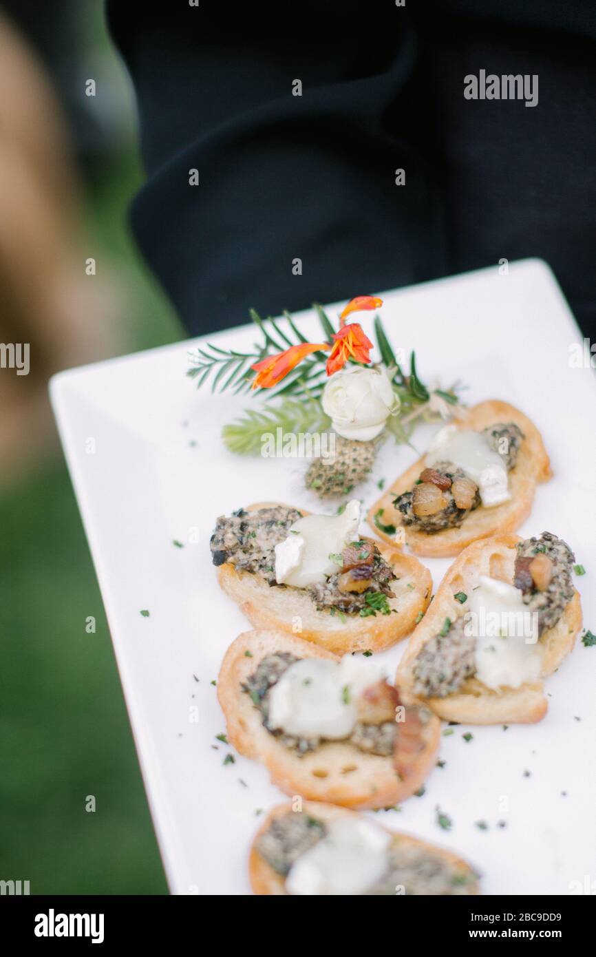 Primo piano dei crostini serviti da un server in occasione di un evento formale Foto Stock