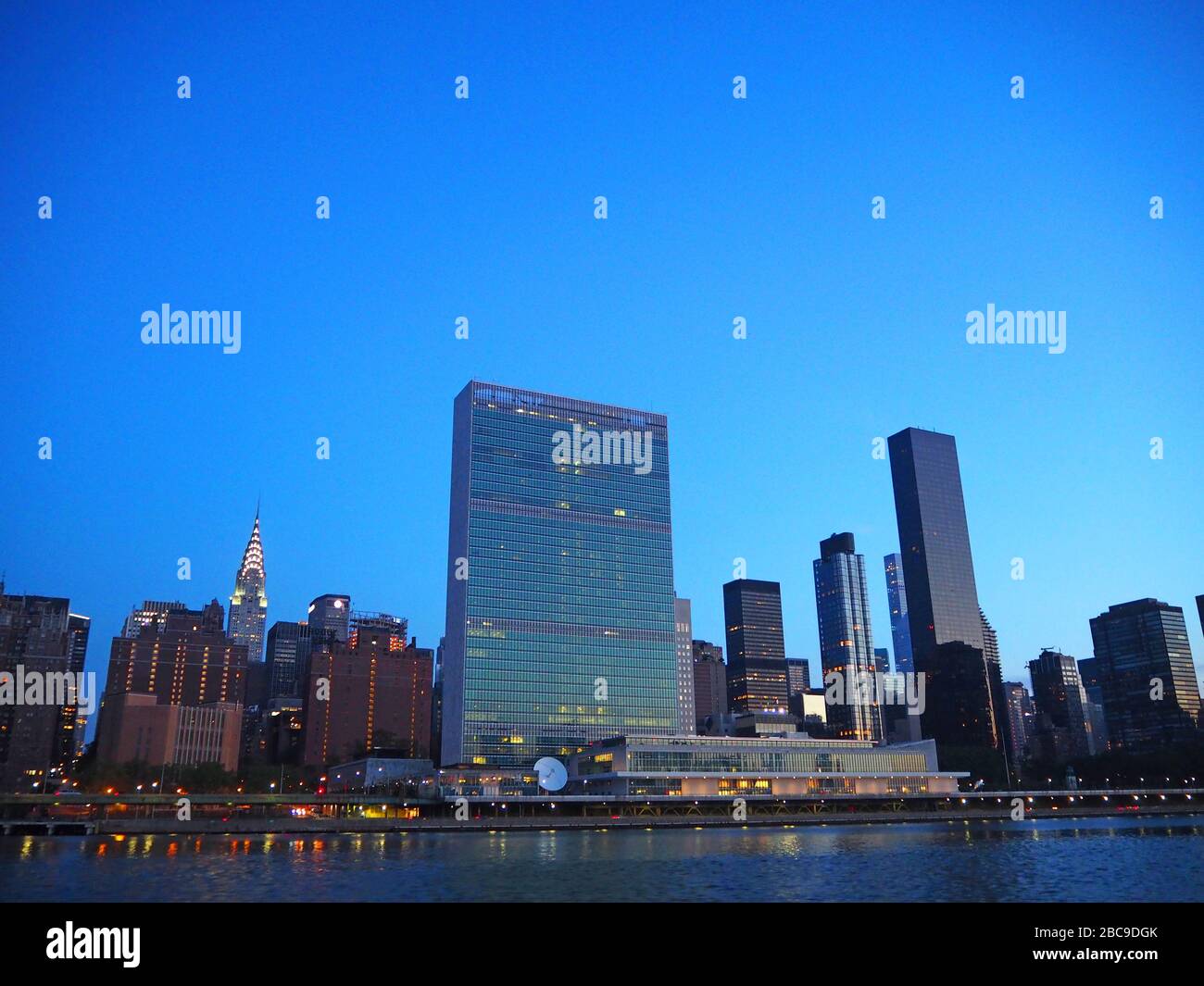 Sede centrale delle Nazioni Unite con Chrysler Building in background all'alba, visto dal fiume est, New York, Stati Uniti Foto Stock