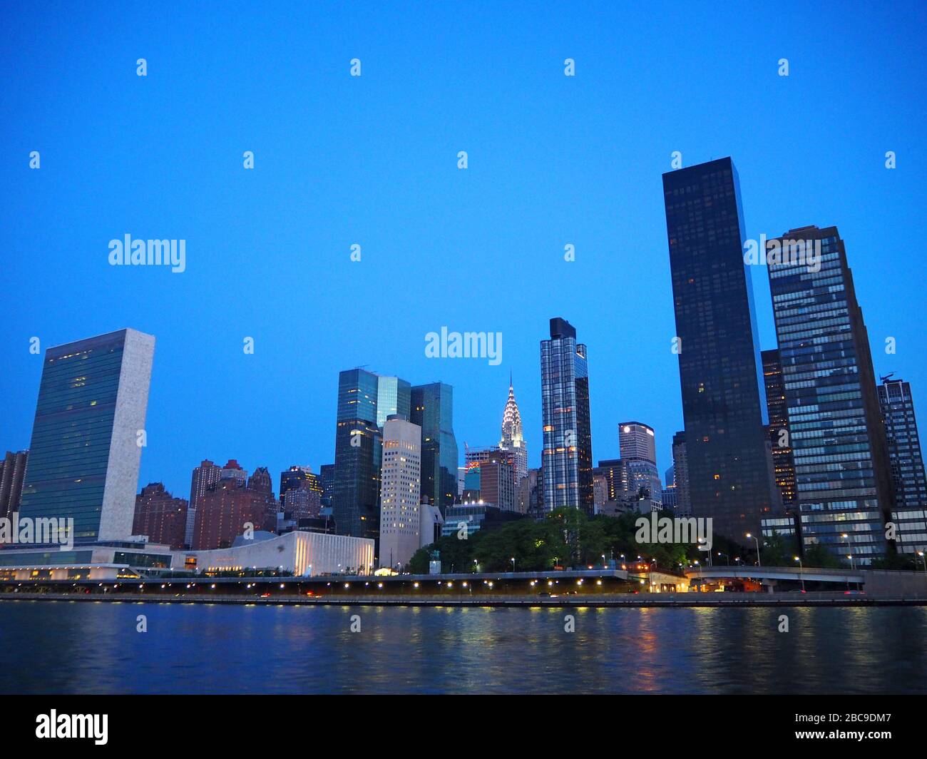 Sede centrale delle Nazioni Unite con Chrysler Building in background all'alba, visto dal fiume est, New York, Stati Uniti Foto Stock