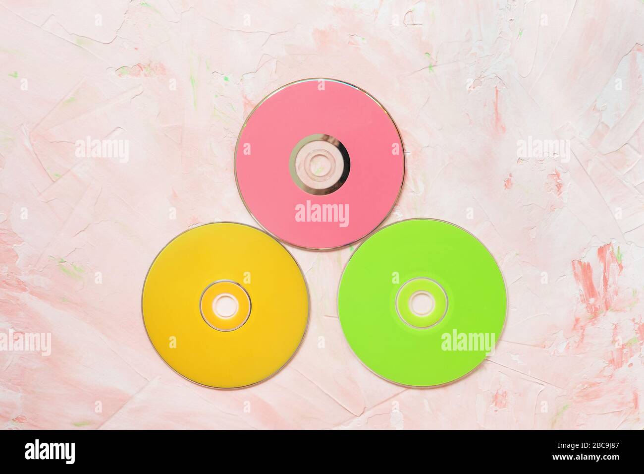 Dischi CD o DVD rossi su rosa. Retro sfondo minimalista, spazio copia Foto Stock