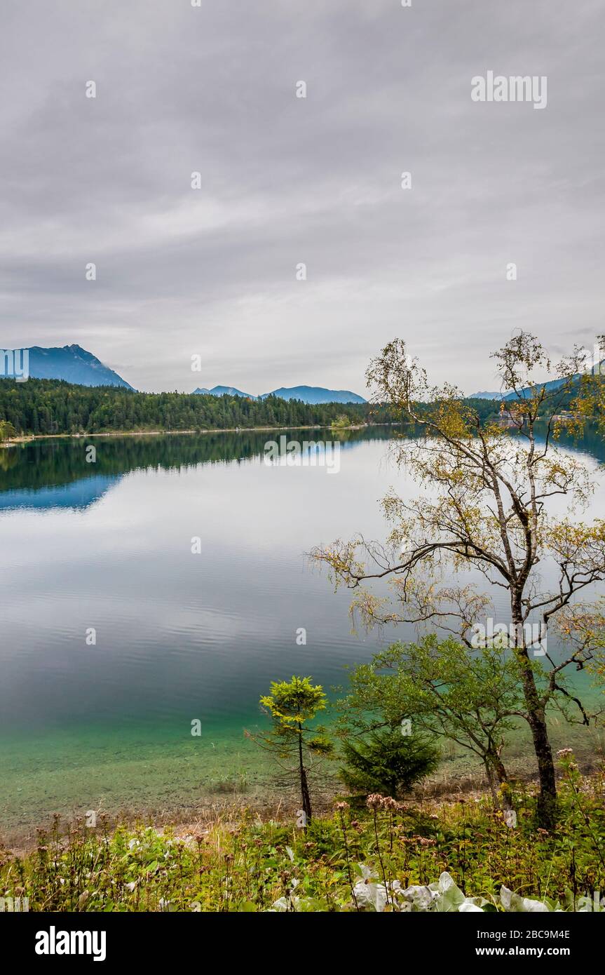 Eibsee dalla riva occidentale, tempo nuvoloso sopra una vista in terra Werdenfelser, un verde intenso domina il lago di montagna, Foto Stock