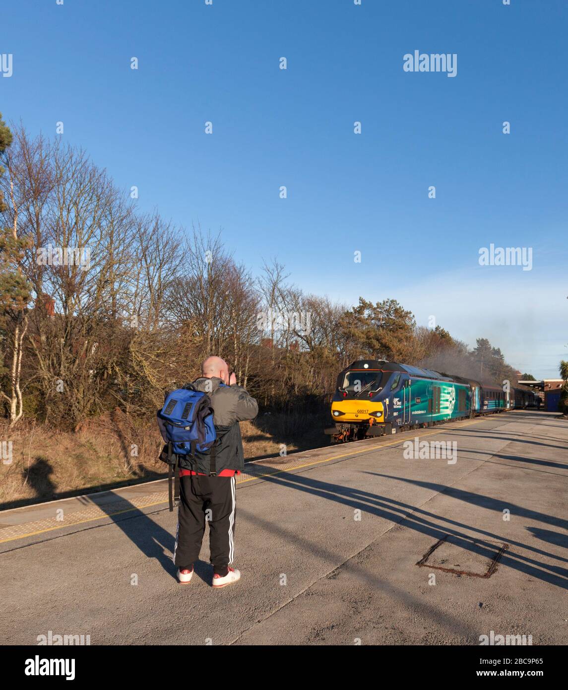 Appassionati di ferrovie / trenino-spotter fotografare una locomotiva di classe 68 di Direct Rail Services su una stazione ferroviaria Foto Stock