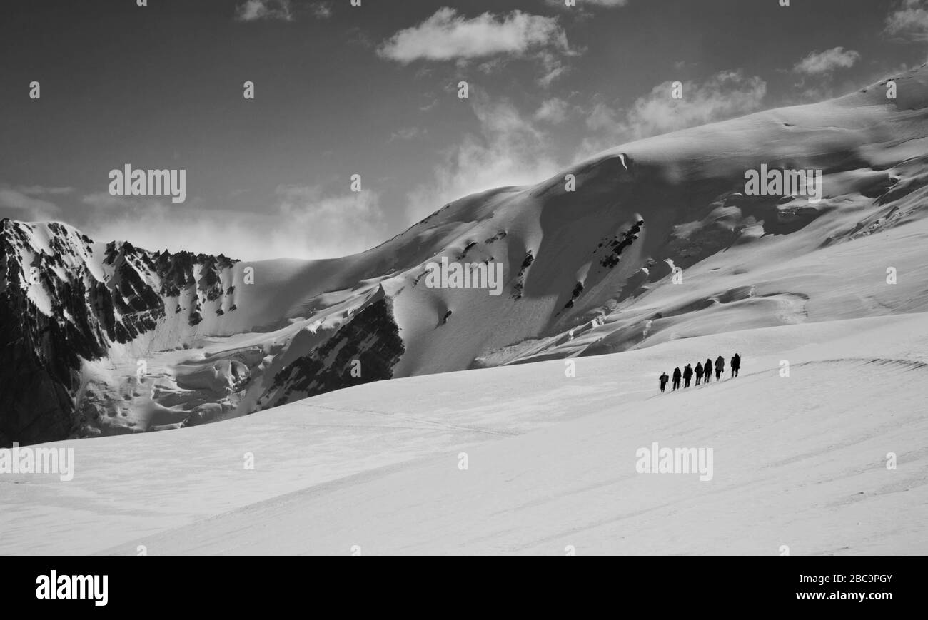Escursione alpinistica sulle montagne innevate del Kirghizistan. Paesaggio bianco e nero. Foto Stock