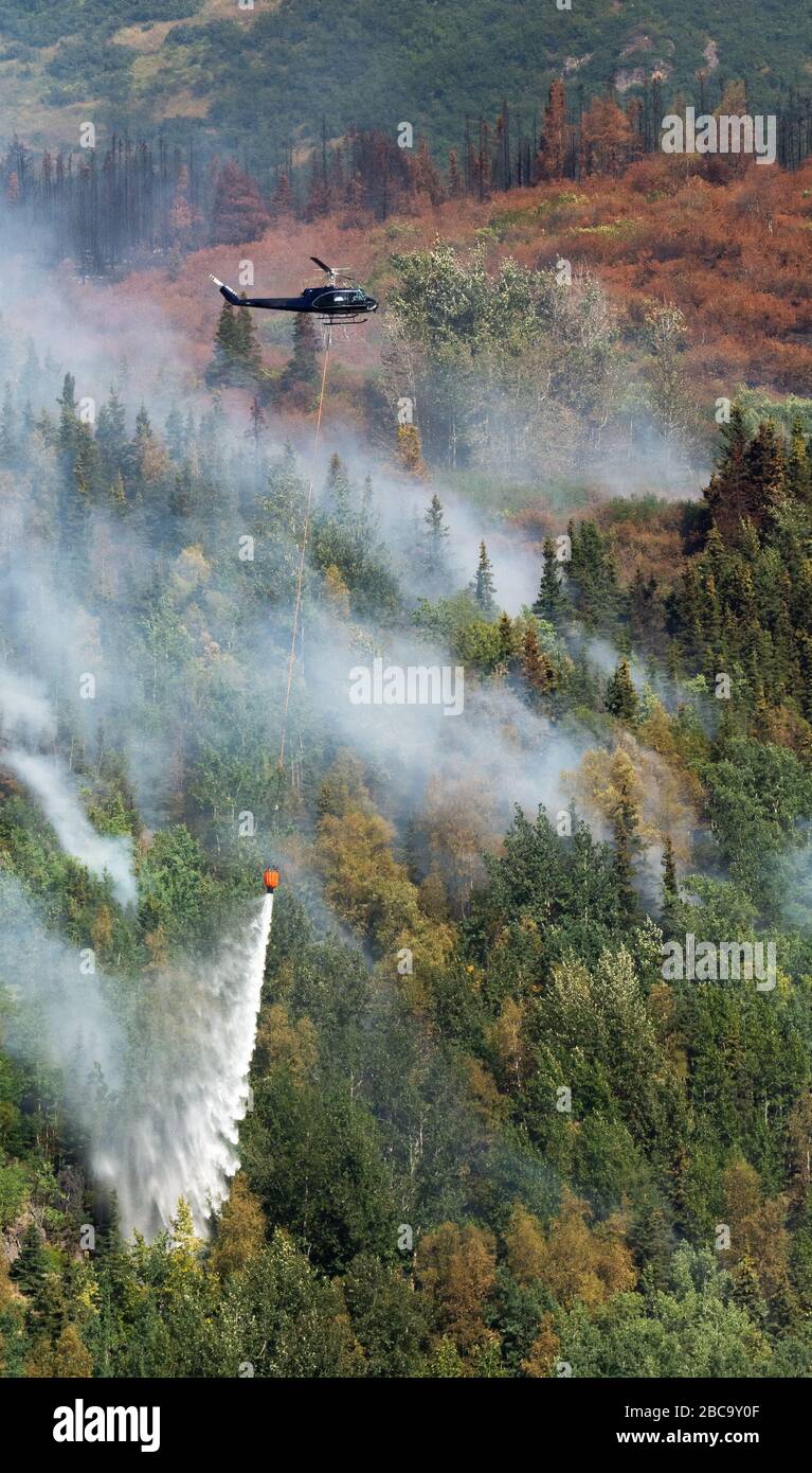 Gocce di elicottero ruscello sull'acqua sul fuoco della foresta dell'Alaska Foto Stock