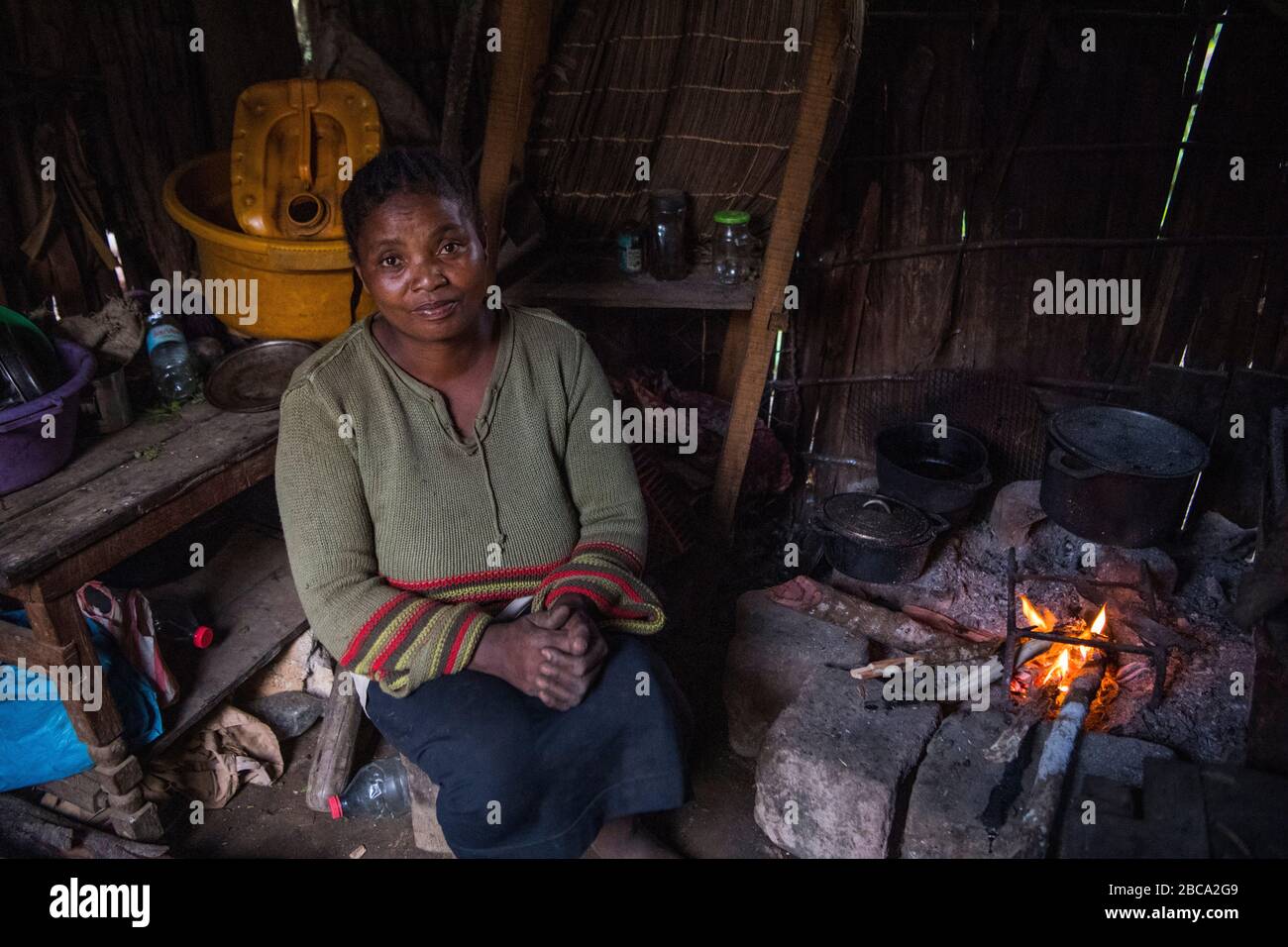 Africa, Madagascar, Andasibe villaggio. Donna accanto al fuoco in casa sua. Foto Stock