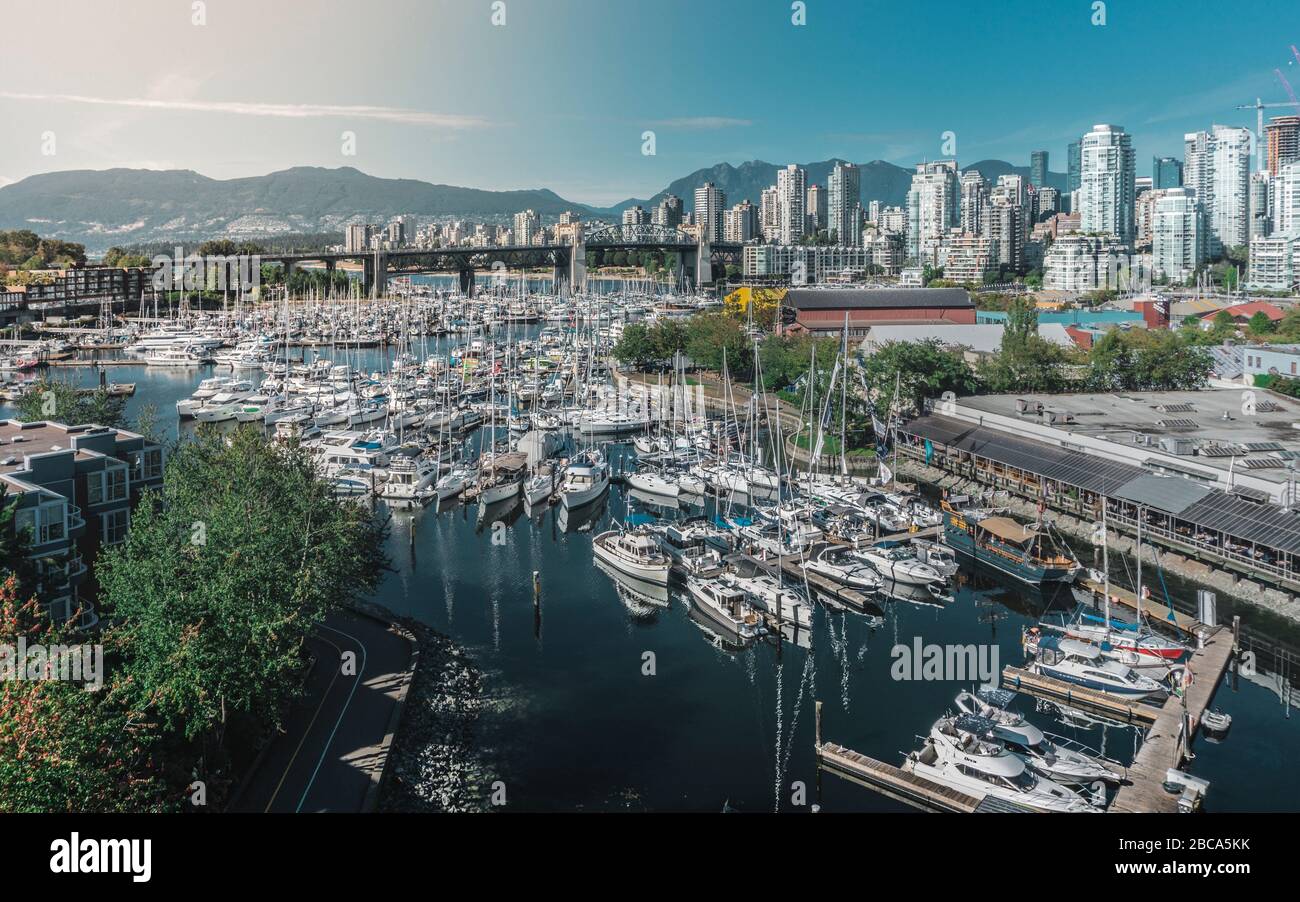 Bella città di Vancouver durante l'estate. Tante barche, vele, edifici moderni, oceano e montagne. Foto Stock