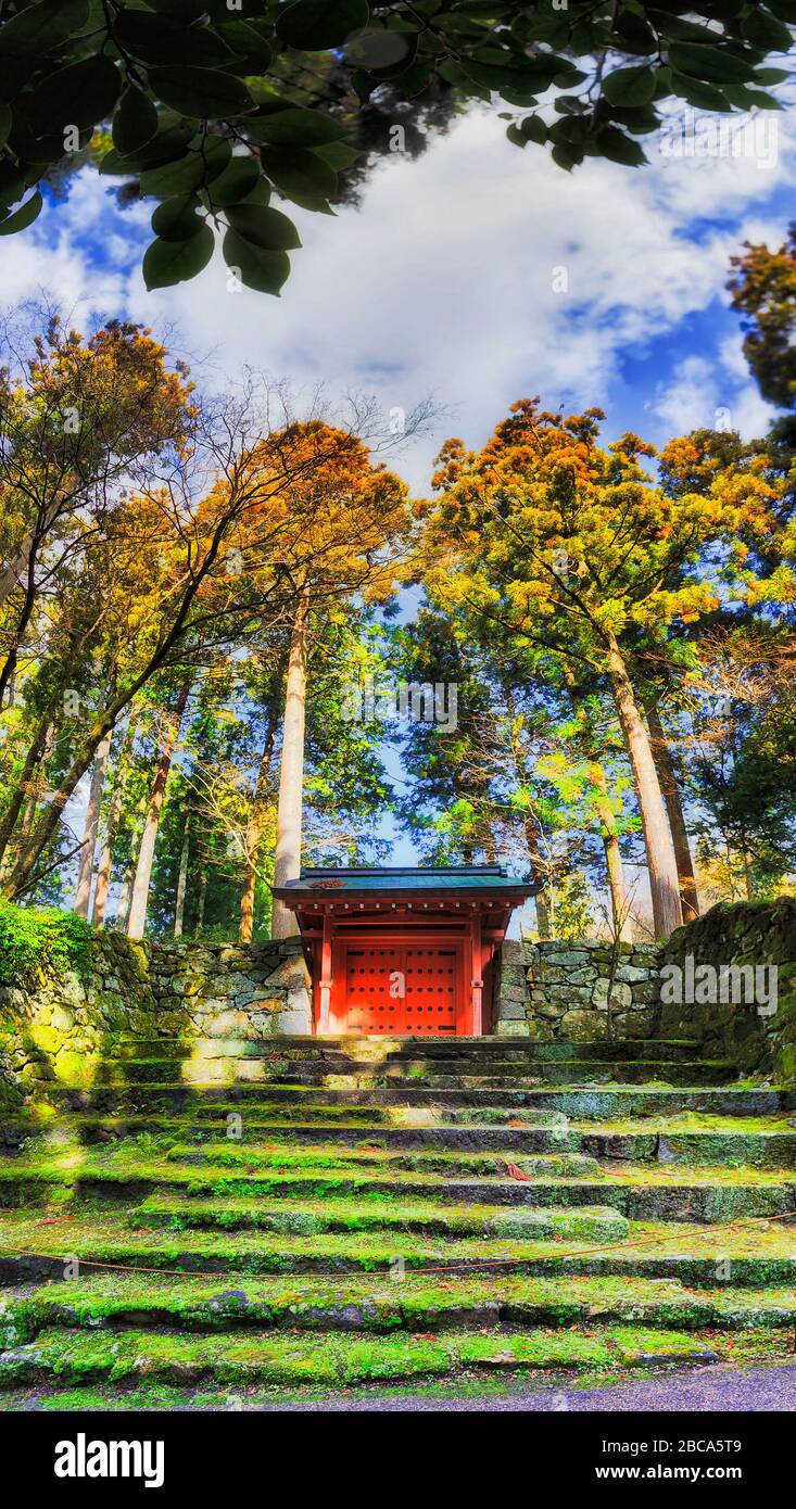 Il cancello rosso in muschio coperto muro di pietra nel villaggio di Ohara, Giappone. Foto Stock