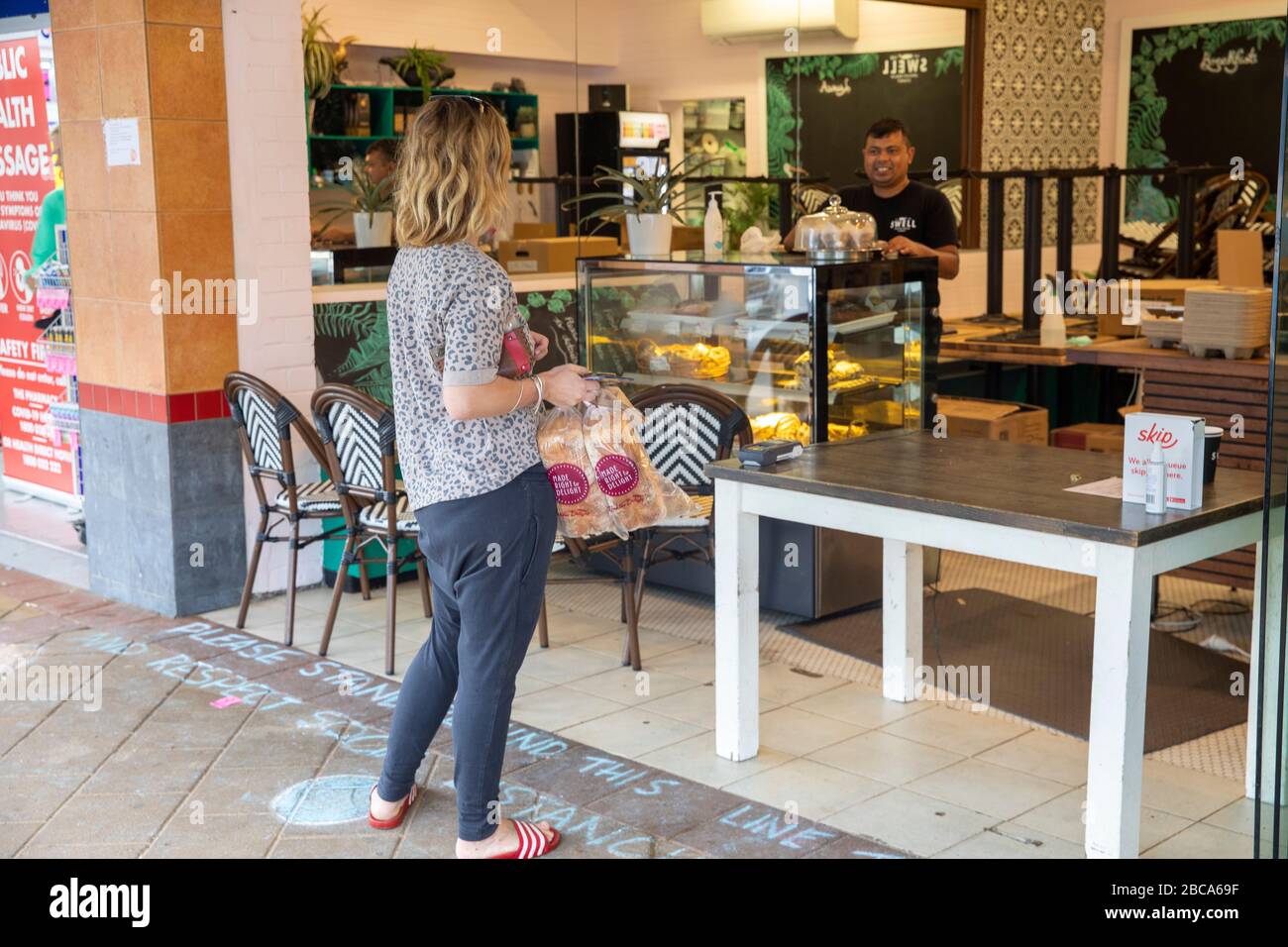 Sydney, Australia. Sabato 4th Aprile 2020. Il caffè di Sydney usa il gesso per indicare vi preghiamo di sostare qui i punti sul sentiero per mantenere l'allontanamento sociale. Credit Martin Berry/Alamy Live News Foto Stock