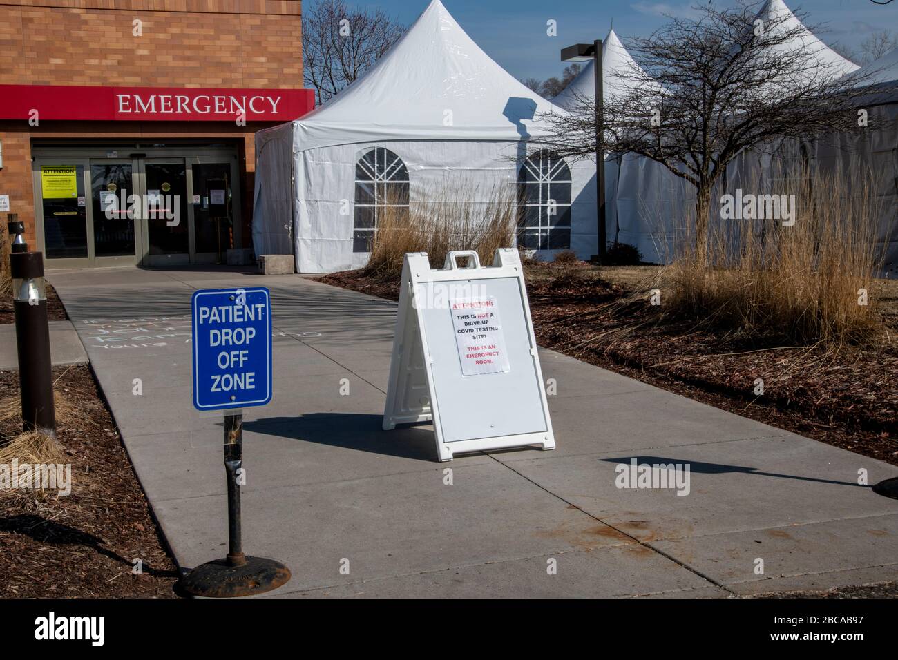 Maplewood, Minnesota. Ospedale di San Giovanni. Le tende sono configurate per lo screening dei pazienti per il coronavirus prima di entrare nella sala di emergenza con un cartello sta Foto Stock