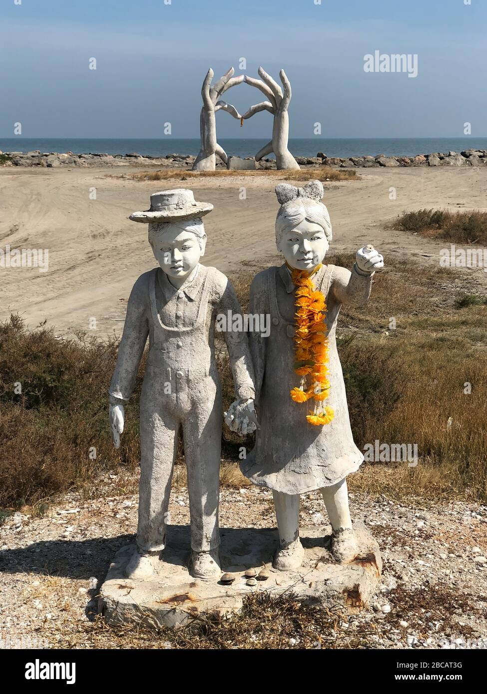 Una gigantesca scultura senza titolo di mani con le dita che toccano insieme a figure maschili e femminili con le mani afferrate creano un mistero. Foto Stock