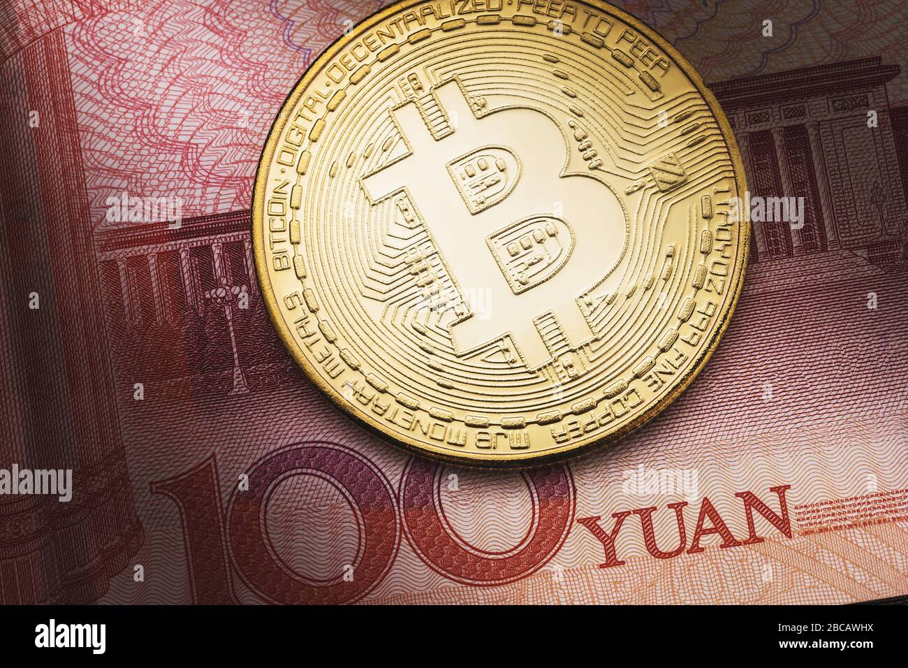 Bitcoin sullo sfondo di cento yuan, primo piano. Il concetto di influenza delle valute l'una sull'altra Foto Stock