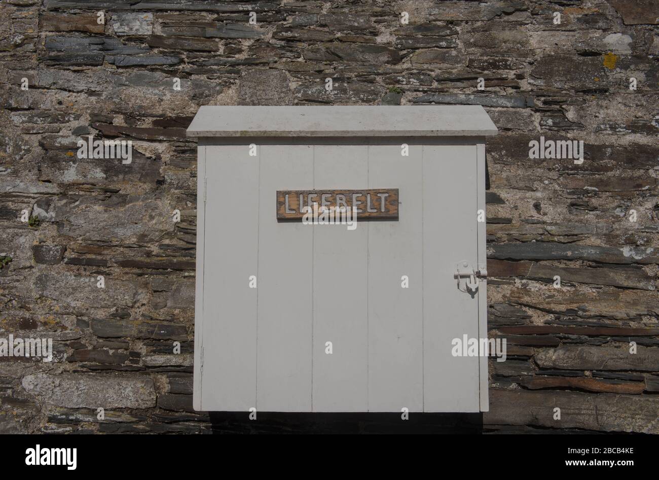 Vecchia scatola di legno attaccata ad un muro di pietra di granito che contiene una cinghia di vita e segno sull'esterno a Cotehele Quay sul Tamar di fiume nella Cornovaglia rurale, Foto Stock