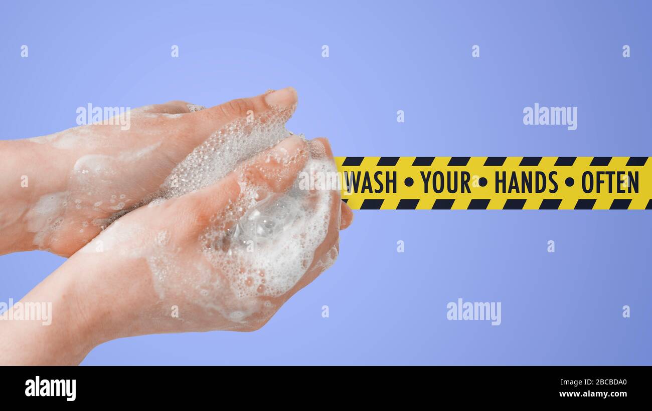 Concetto di lavaggio delle mani. Donna che si sporca le mani e un nastro di sicurezza con il messaggio: Lavarsi le mani spesso Foto Stock