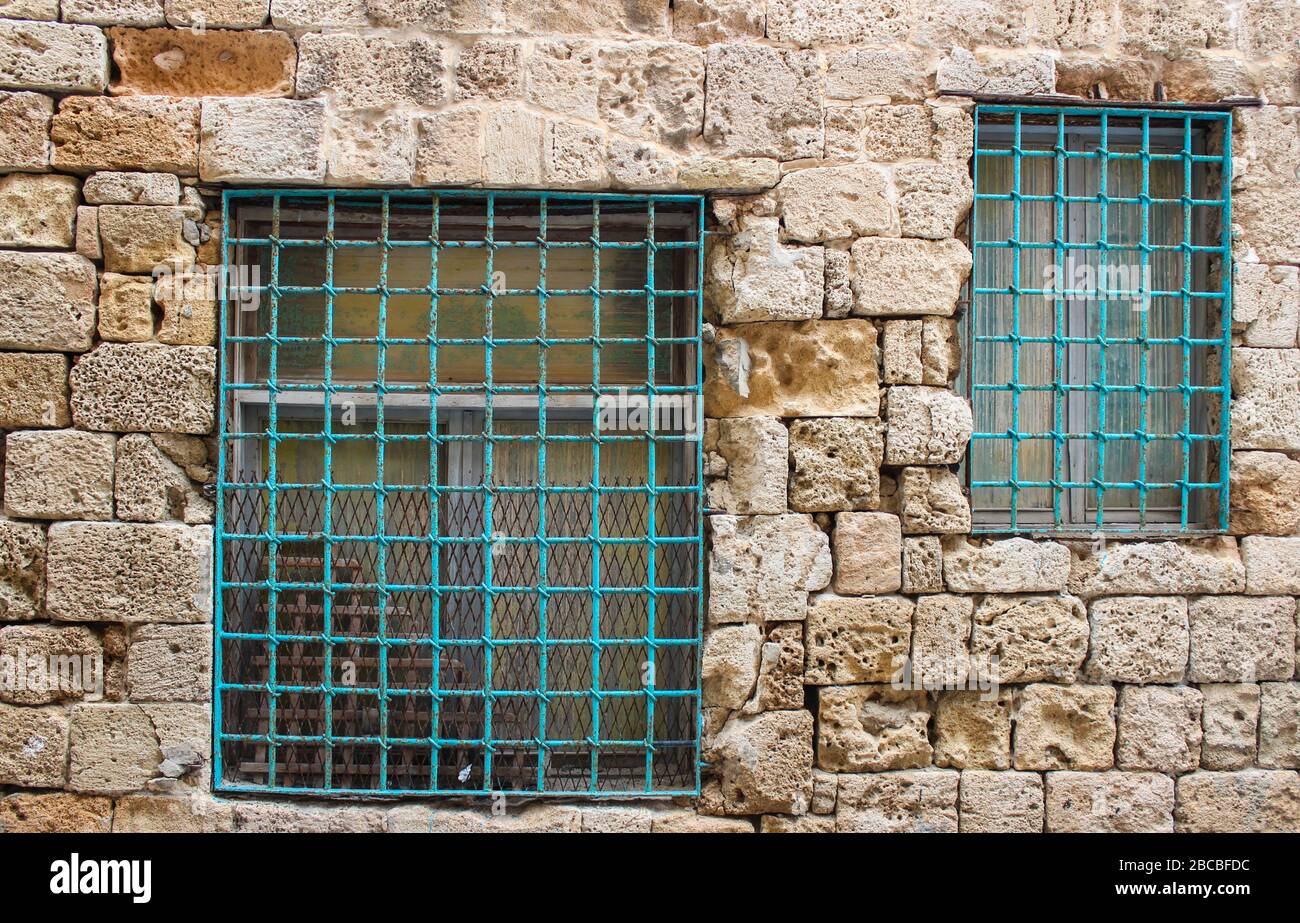 Finestre bloccate in un vecchio muro di arenaria porosa dilatata Foto Stock