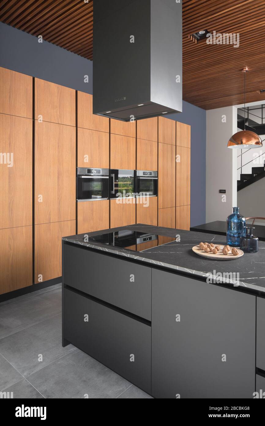 Moderna isola cucina grigia con armadietto in legno. Foto Stock