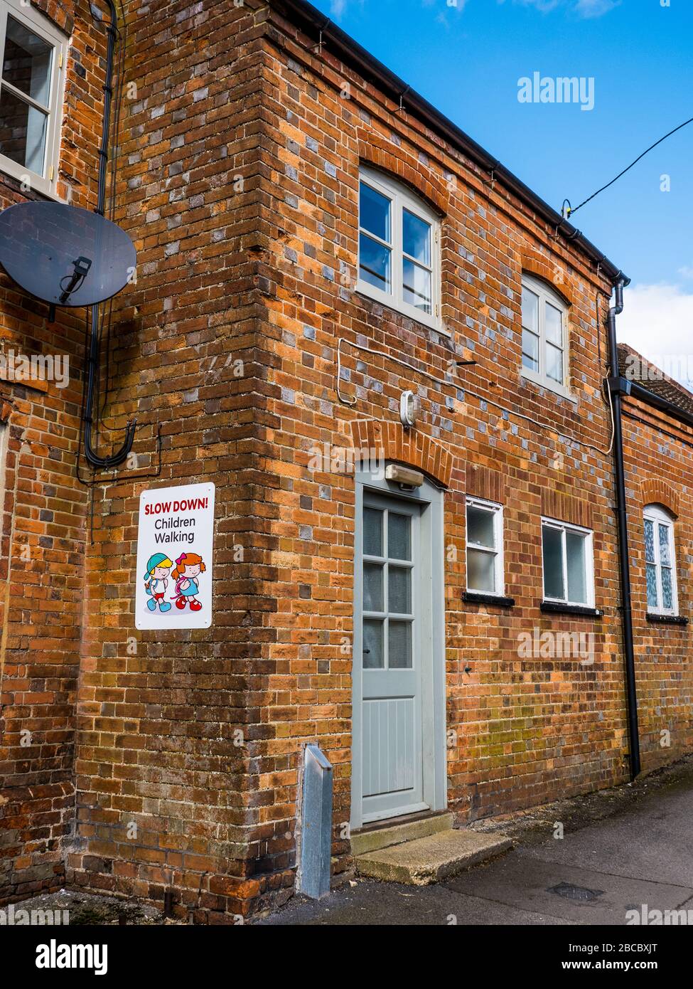 Slow Down Bambini Walking Sign, Ferry Lane, Great Bedwyn, Wiltshire, England, UK, GB. Foto Stock