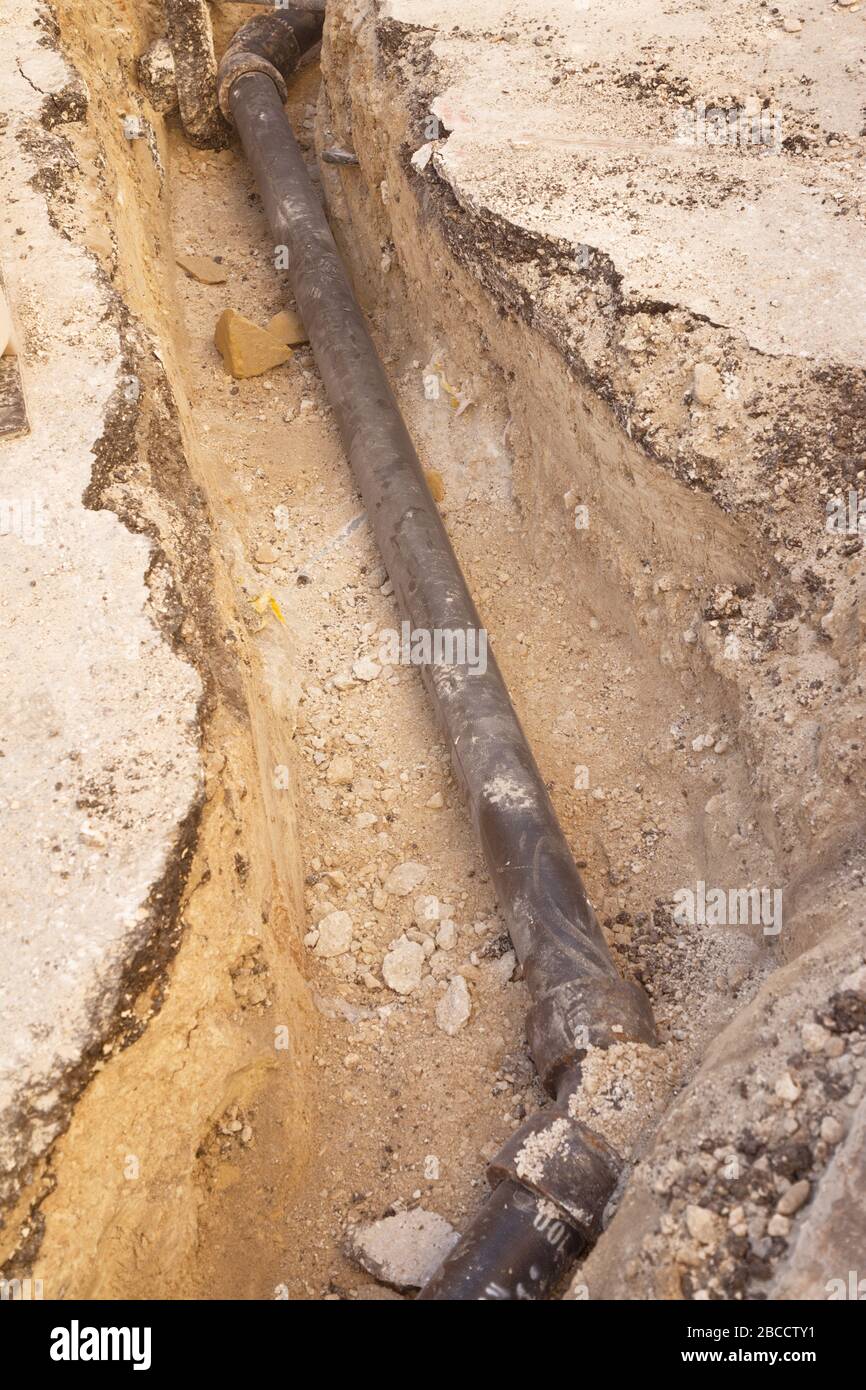 lavori di tubature che vengono posati in una trincea nel terreno Foto Stock