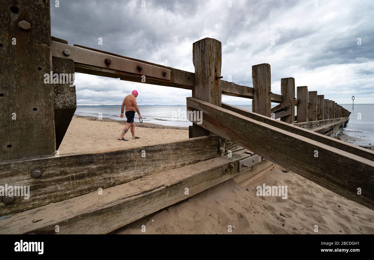 Portobello, Edimburgo, Scozia, Regno Unito. 4 aprile 2020. Nel secondo fine settimana del blocco del coronavirus nel Regno Unito, Paul Edwards da Portobello prende il suo esercizio all'aperto giornaliero ammissibile da nuoto in acqua aperta 1400m nel Firth of Forth. Iain Masterton/Alamy Live News Foto Stock