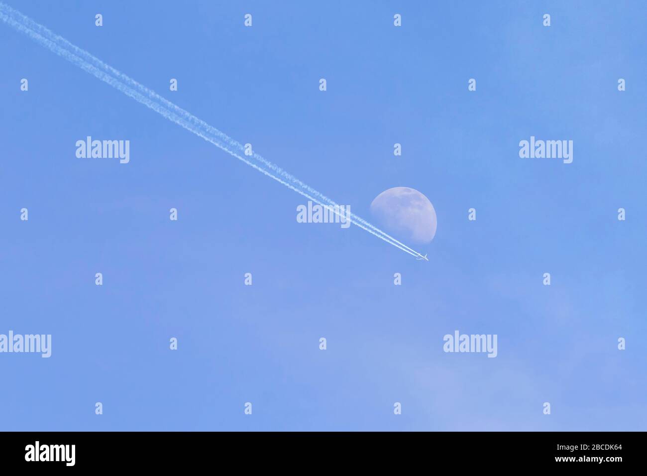 Volo aereo di linea alta sorpassava la mezza luna sopra Northampton, Inghilterra, Regno Unito. Foto Stock