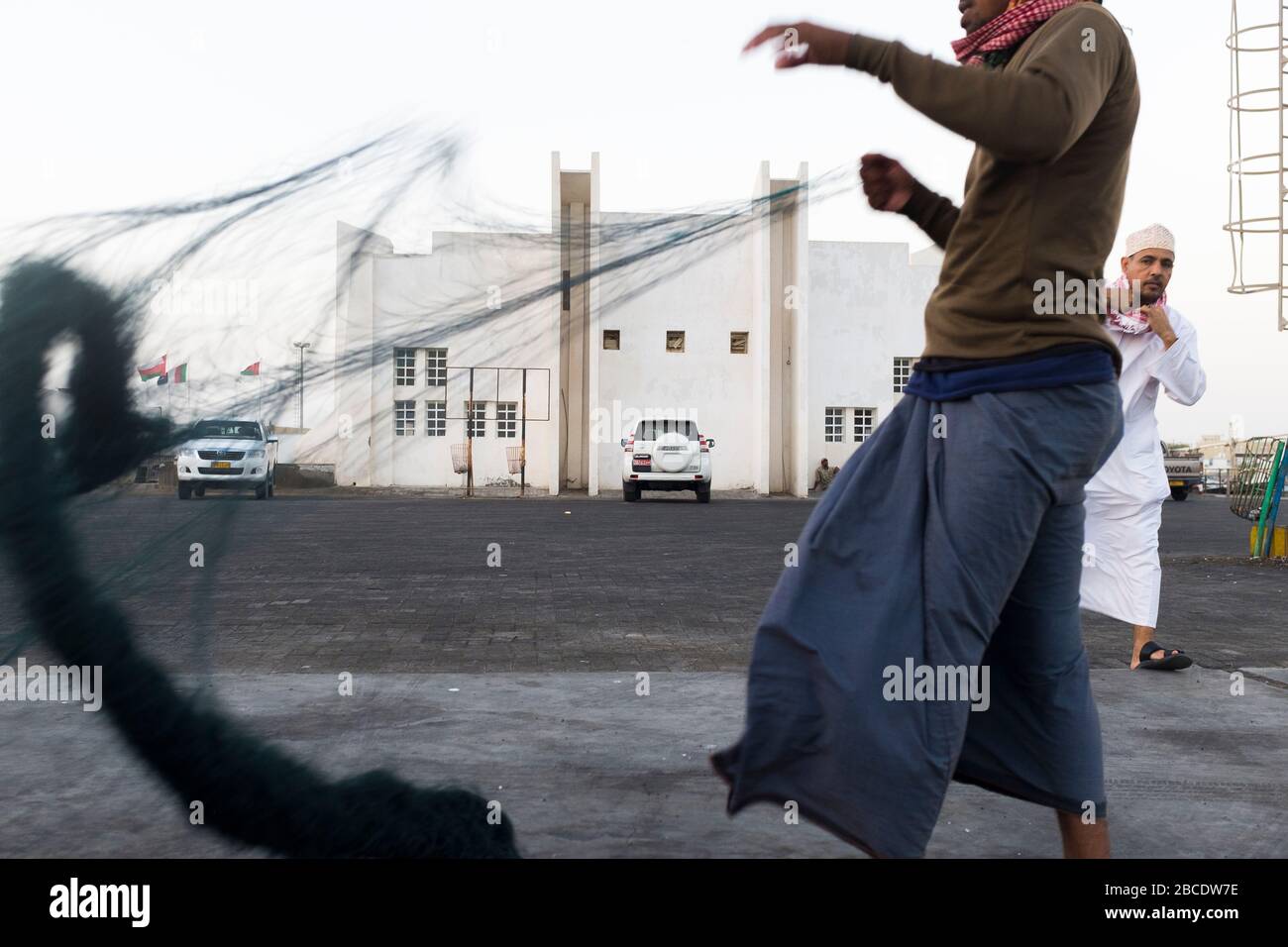 La cattura giornaliera di pesce viene sbarcata, ispezionata da potenziali acquirenti e venduta all'asta a sur, nel nord-est dell'Oman Foto Stock