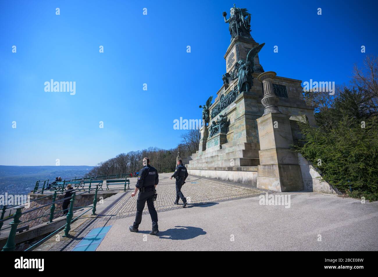 04 aprile 2020, Hessen, Rüdesheim: Due poliziotti pattugliano il Monumento Niederwald. Le strade di accesso al Niederwalddenkmal e i parcheggi direttamente al punto di escursione sono chiusi. I visitatori possono raggiungere l'attrazione solo a piedi o in bicicletta. La polizia effettuerà i controlli. Foto: Andreas Arnold/dpa Foto Stock