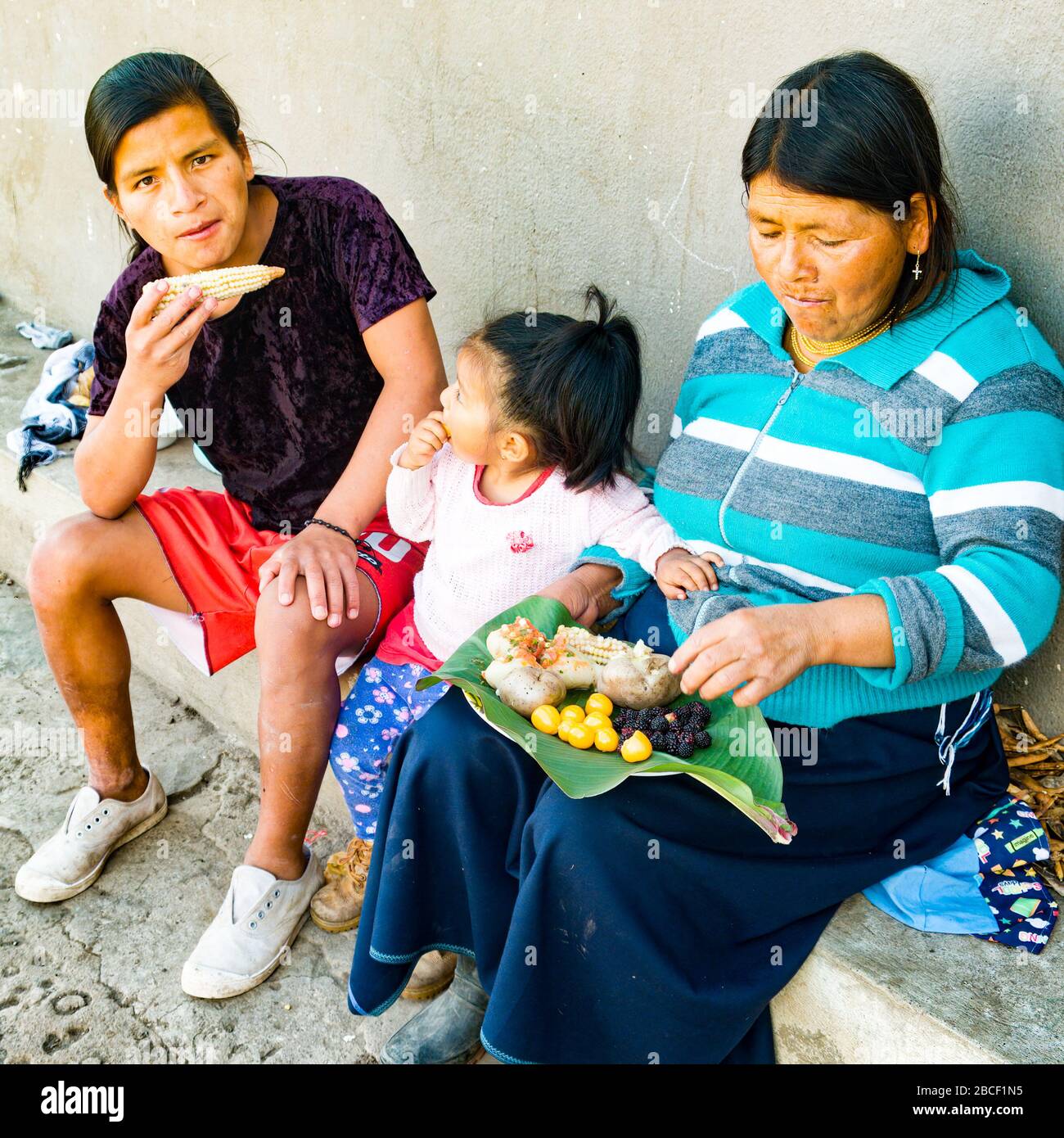 Attività di coronavirus 5of6 cibo snack fuori del piatto di foglie di terra, 3 generazioni, nonna figlio mangiare nel patio della comunità di San Pedro Cotacachi Foto Stock