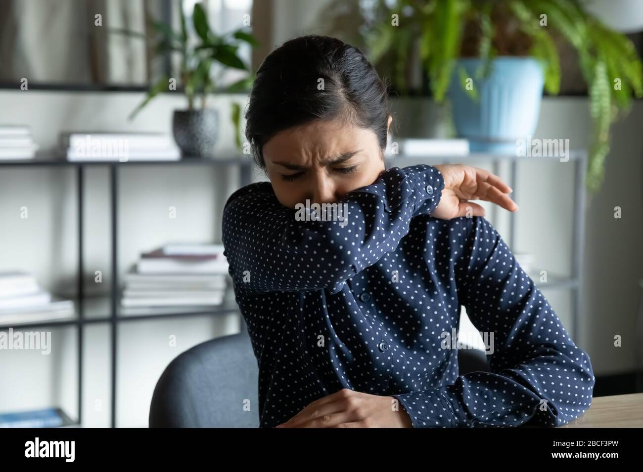 Giovane donna malsana che si sente malessere sul posto di lavoro, ha covid 19 sintomi. Foto Stock