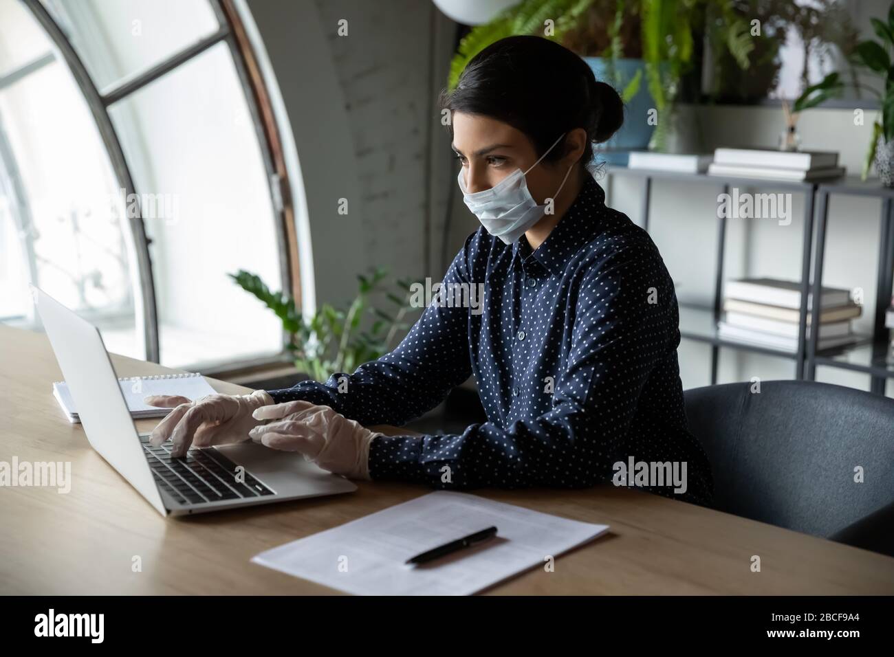 Dipendente indiano dell'azienda che lavora su un notebook sul posto di lavoro. Foto Stock