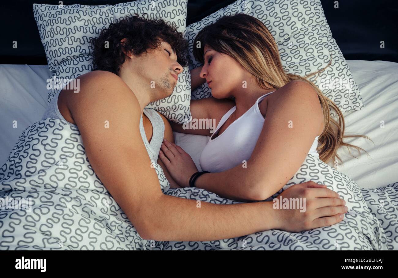 Giovane dorme abbracciata a letto Foto Stock