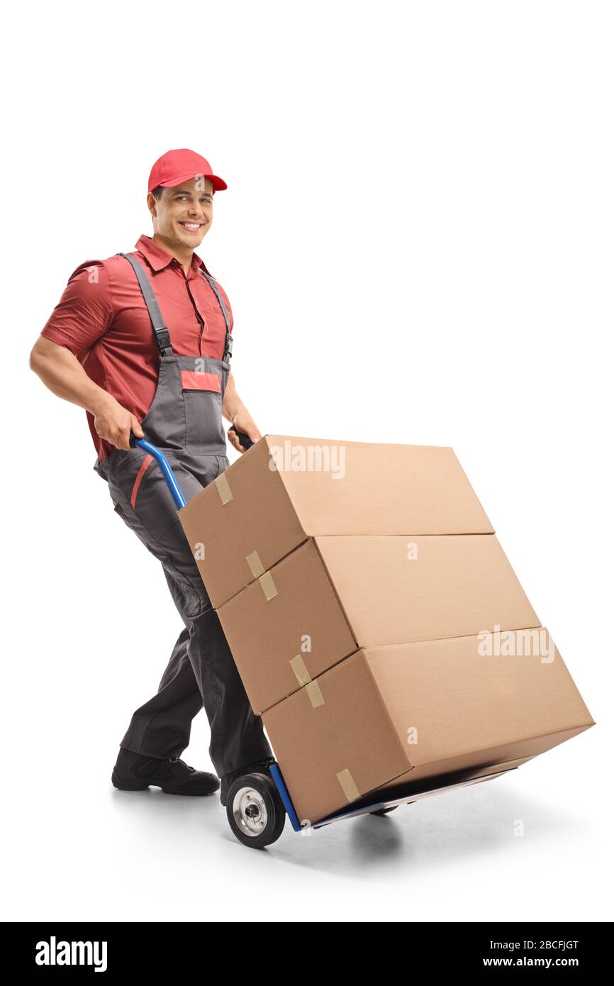 Lavoratore maschile che spinge un camion a mano caricato con scatole isolate su sfondo bianco Foto Stock