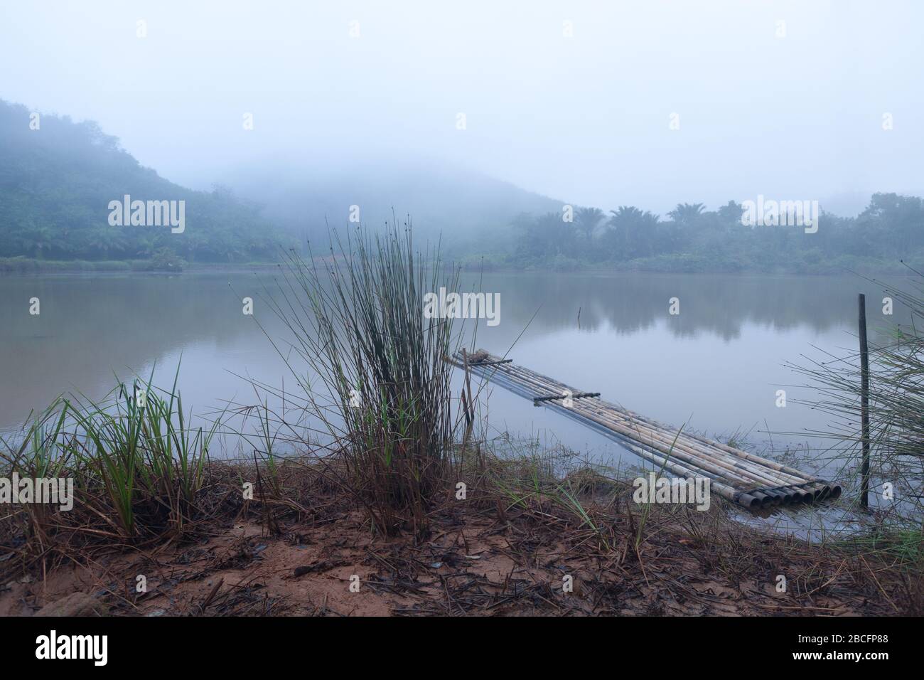 Paesaggio di zattera di bambù che galleggia sull'acqua al mattino e nebbia Foto Stock