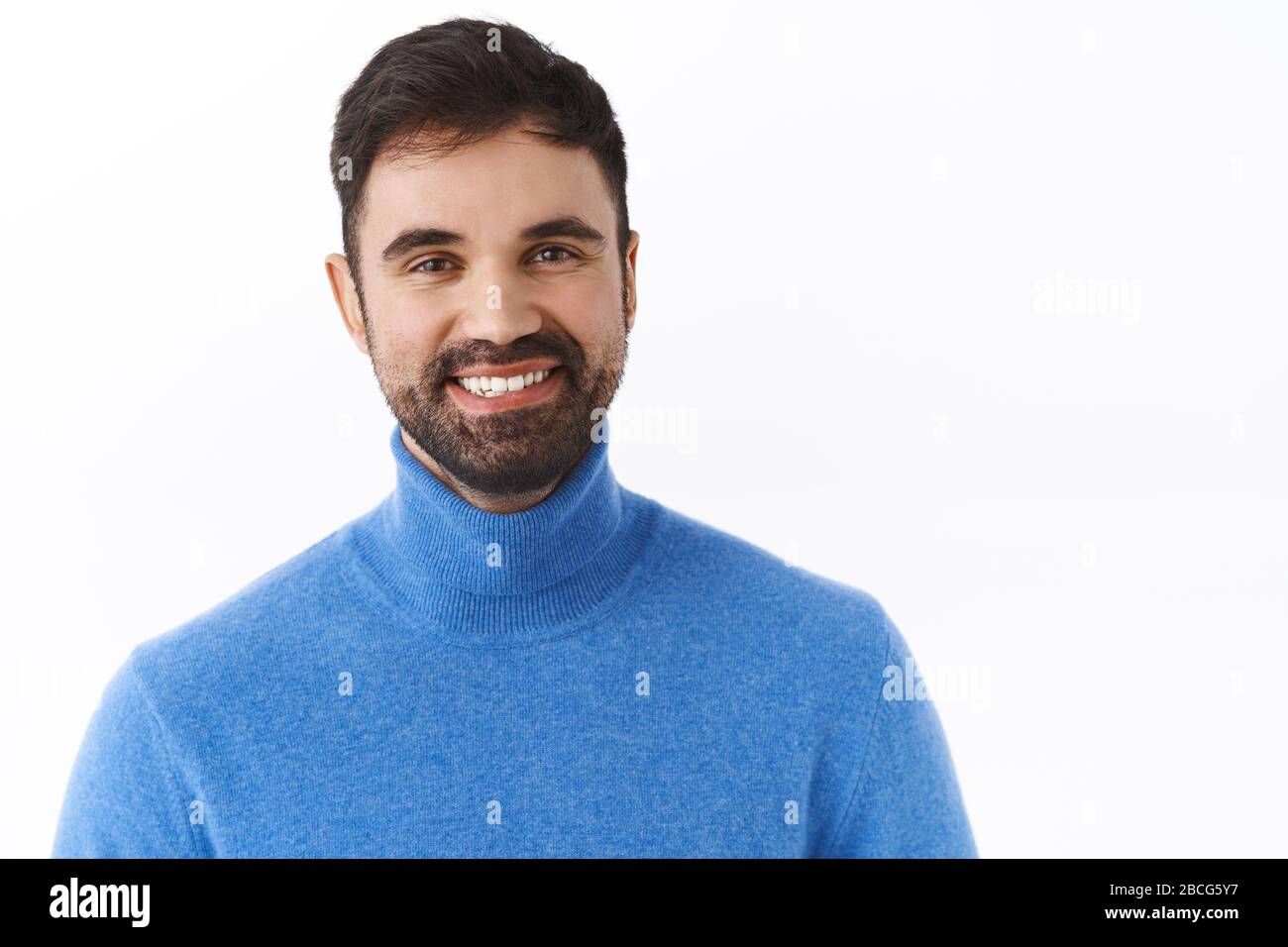 Ritratto ravvicinato di bell'uomo d'affari di successo con barba, sorridente felice e soddisfatto, esprimere entusiasmo e positività, rimanendo acceso luminoso Foto Stock