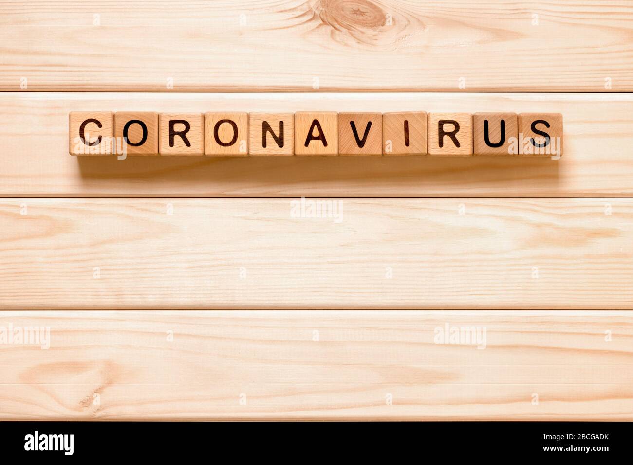 Coronavirus di parola con blocchi di legno, cubi su sfondo di legno. COVID-19. Concetto di autoisolamento. Quarantena del coronavirus. Lavoro da casa. Rimani a casa Foto Stock