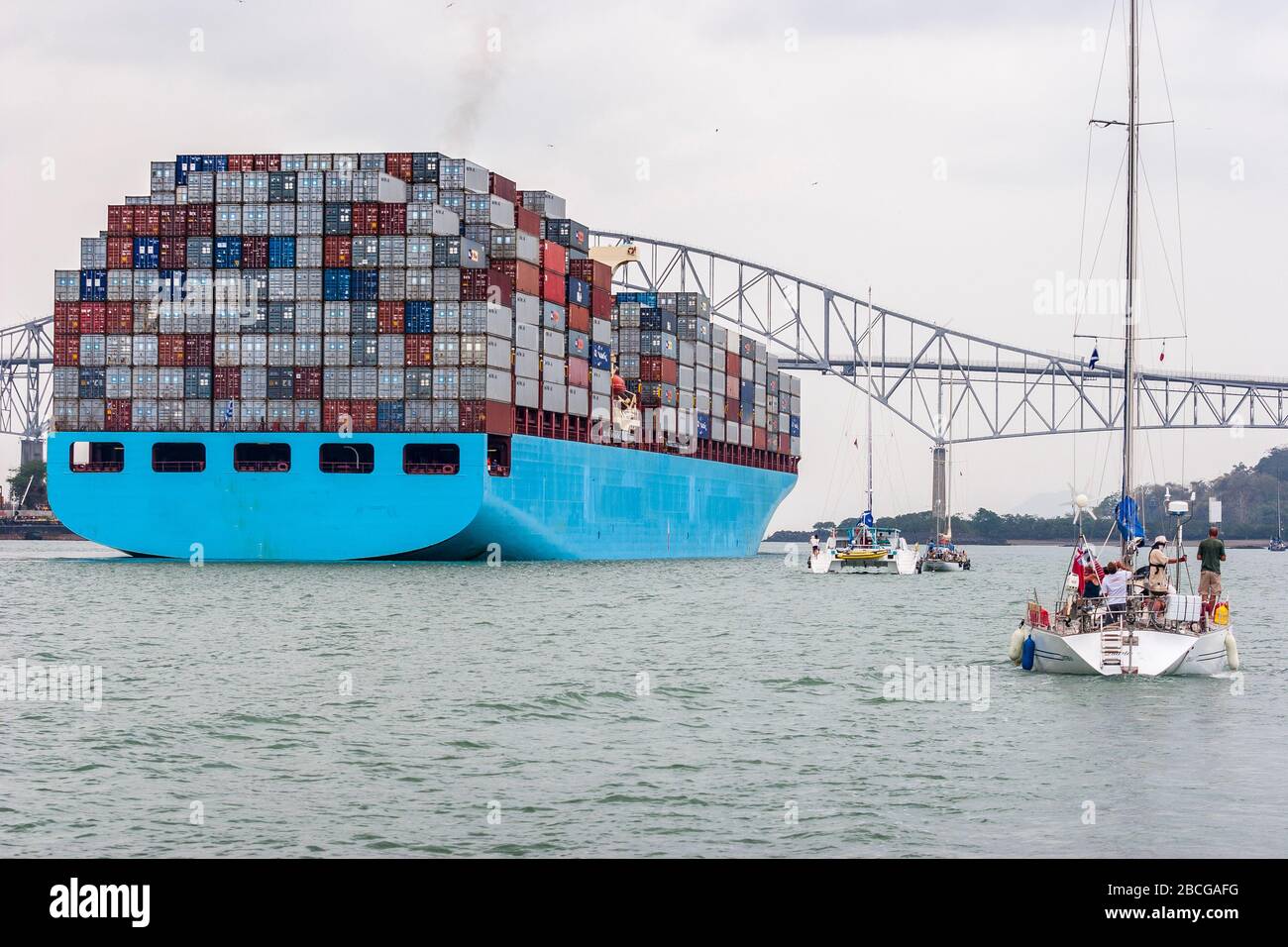 Nave container che lascia il canale di Panama e passa il ponte delle Americhe, l'unico collegamento stradale tra il Nord e il Sud America Foto Stock
