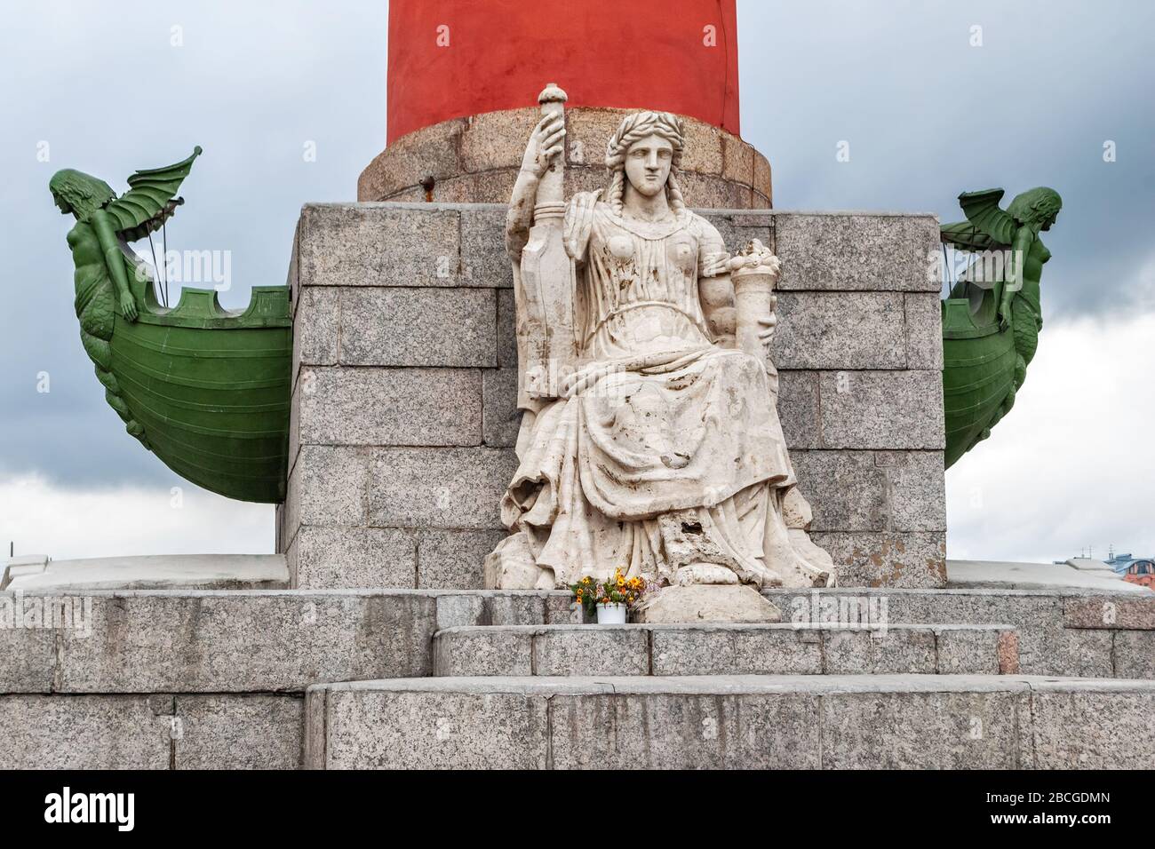 Scultura ai piedi della colonna rostrale sulla freccia dell'isola di Vasilievsky in una casa estiva nuvolosa. Foto Stock