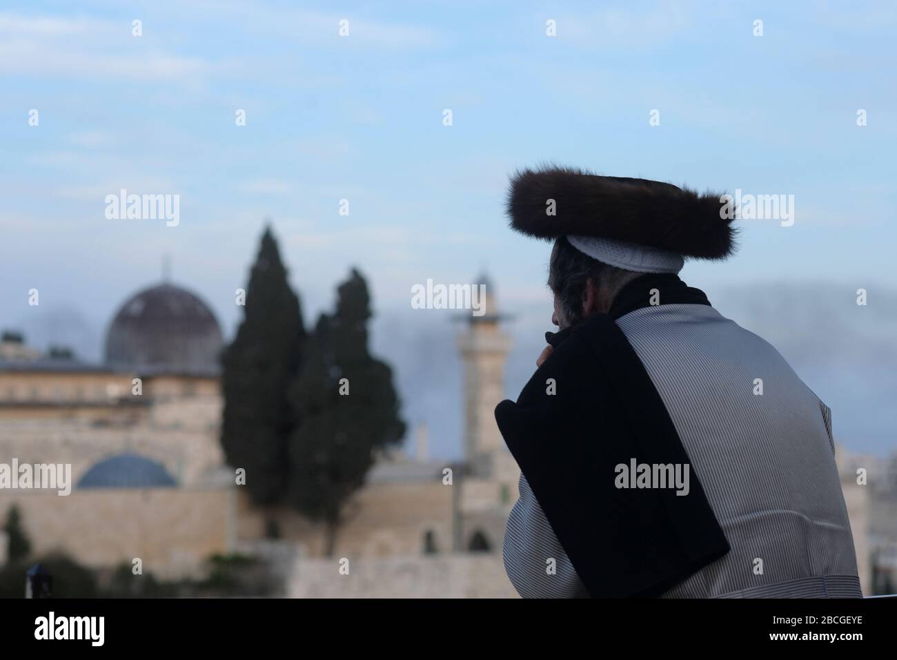 Un ebreo asidico che indossa uno shtreimel un cappello di pelliccia indossato da molti uomini ebrei Haredi sposati guarda alla moschea di al Aqsa un santuario islamico situato sul monte del Tempio noto ai musulmani come l'Haram esh-Sharif nella Città Vecchia Gerusalemme Est Israele Foto Stock