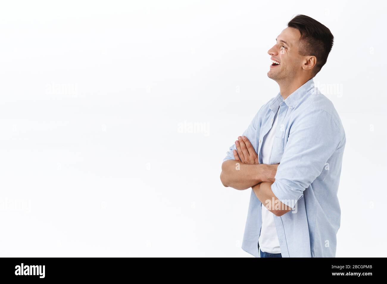 Profilo ritratto di bel ragazzo di famiglia felice adulto in camicia, croce mani sul petto, ridendo e sorridendo compiaciuto, guardando lasciato spazio vuoto a. Foto Stock
