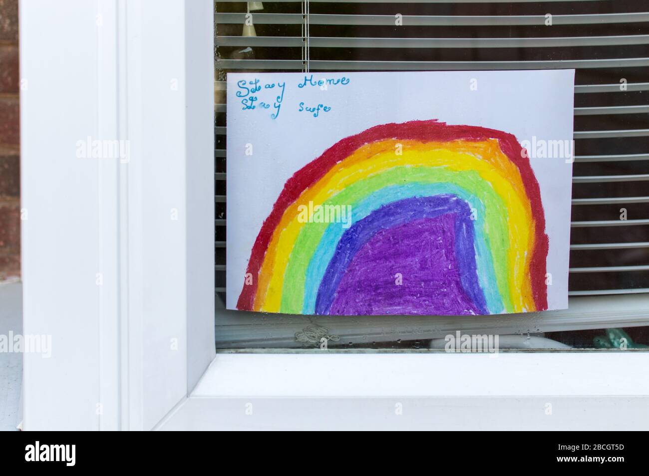 Disegno arcobaleno da parte di un bambino su una finestra di casa Foto Stock