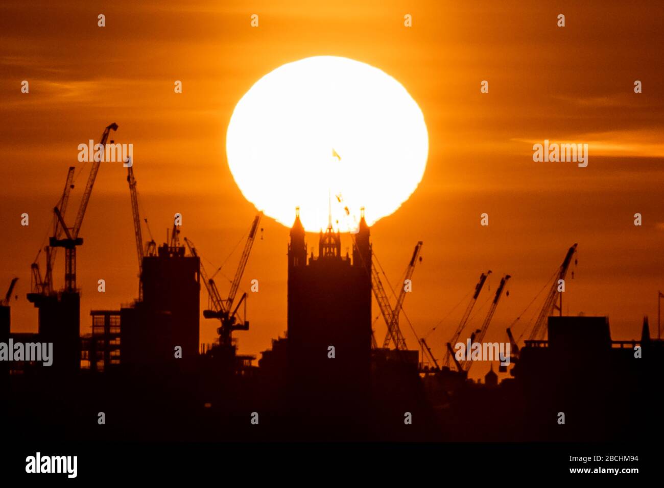 Londra, Regno Unito. 4th aprile 2020. Coronavirus: Un caldo sole serale tramonta sulla Victoria Tower di Westminster. I britannici sono stati esortati a non lasciare che il caldo tempo del weekend li scada dalle loro case, per ridurre la diffusione del coronavirus. Con le previsioni del Regno Unito per godersi il sole di sabato e domenica, il primo ministro Boris Johnson e il segretario alla sanità, Matt Hancock, hanno detto che il pubblico deve resistere alla voglia di svendere le regole di distanziamento fisico. Credito: Guy Corbishley/Alamy Live News Foto Stock