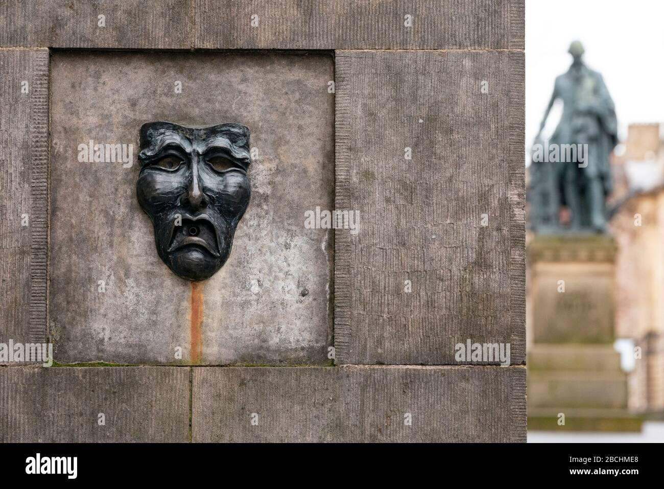 Maschera teatrale in bronzo rilievo con triste volto su High Street wellhead sul Royal Mile a Edimburgo, Scozia, Regno Unito, per indicare la tristezza della cancellazione del festival Edinburgh Fringe 2020. Foto Stock