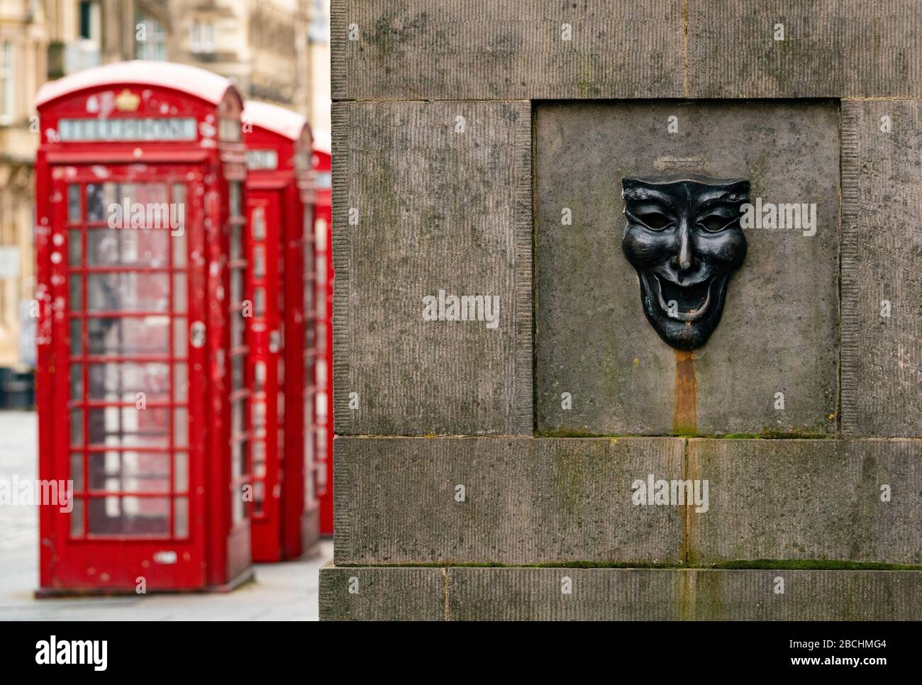 Maschera teatrale in bronzo rilievo con felice volto su High Street wellhead sul Royal Mile a Edimburgo, Scozia, Regno Unito Foto Stock