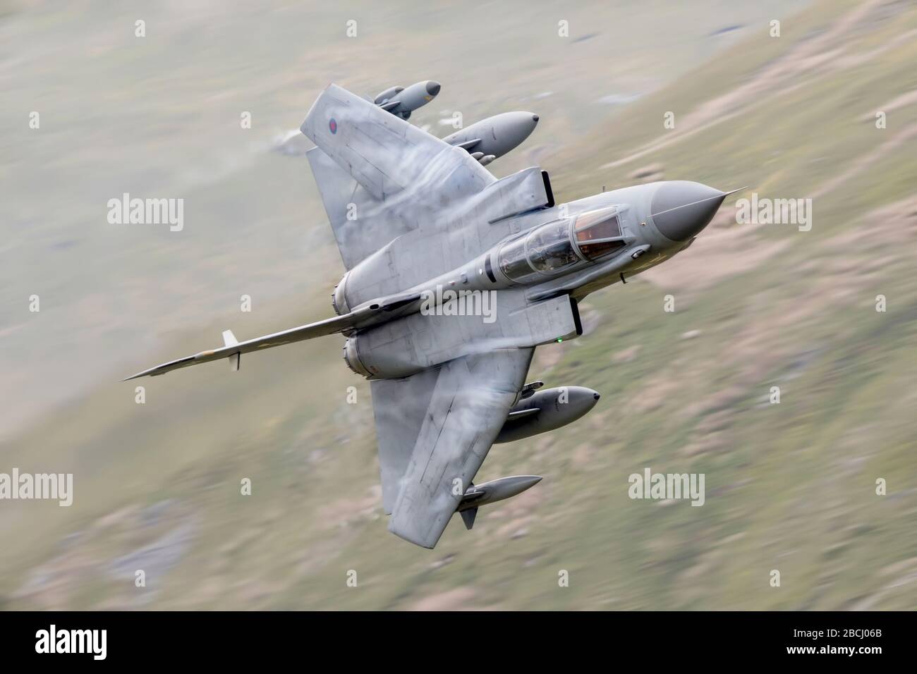 Royal Air Force Tornado GR4 attacco picchiaduro caccia volare veloce e basso a basso livello attraverso una valle con ali dolce schiena. Vapori ad alta velocità Foto Stock