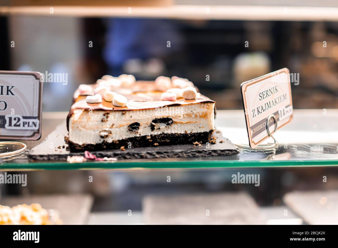 Closeup di esposizione di dulce de leche caramello cheesecake condensato di latte con marshmallows di cioccolato e segno in polacco a Varsavia, Polonia caffè a Cristo Foto Stock