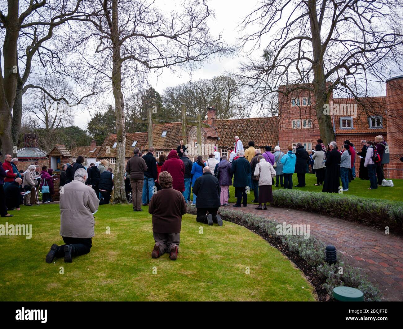 I pellegrini e i visitatori che partecipano alle stazioni della Croce camminano al Santuario di nostra Signora di Walsingham il Venerdì Santo per celebrare la storia di Cristo Foto Stock
