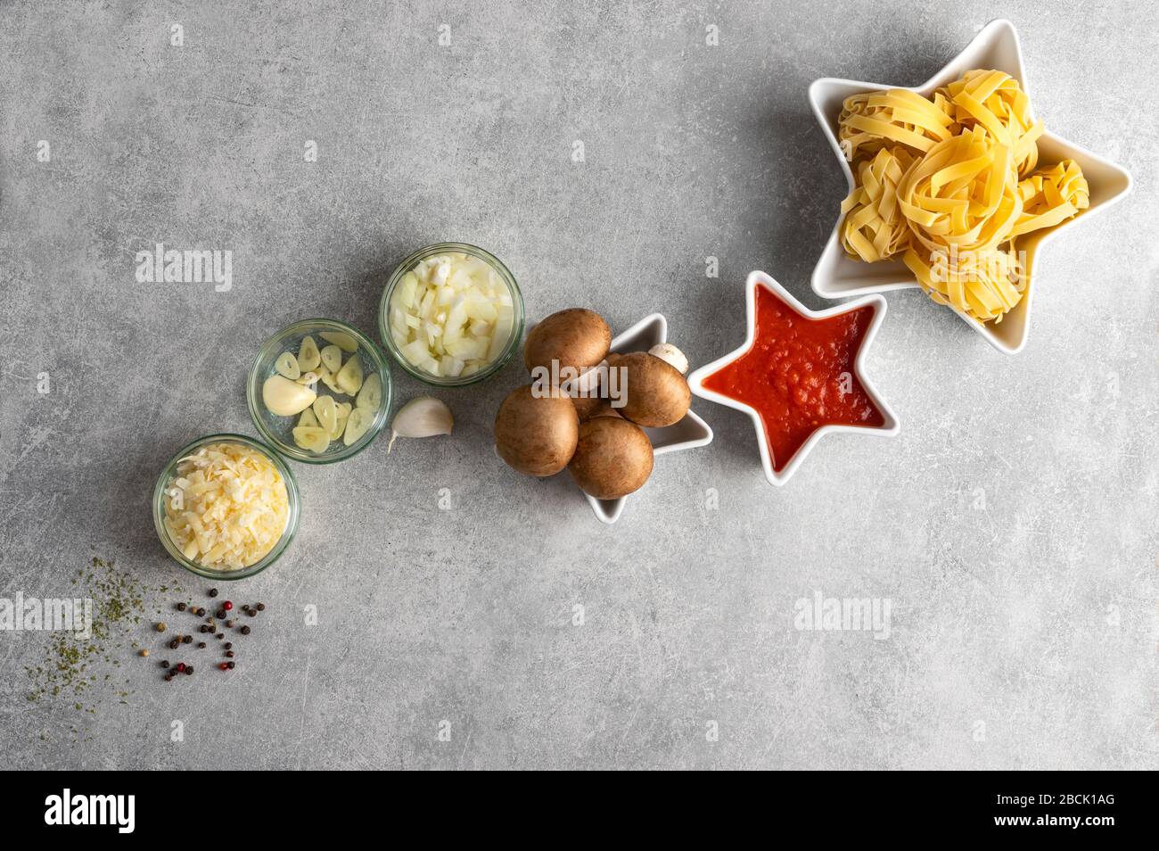 Pasta secca, funghi e verdure su pietra grey sfondo tavolo vista dall'alto, con spazio copia. Concept star composizione tagliatelle e bologno vegano Foto Stock