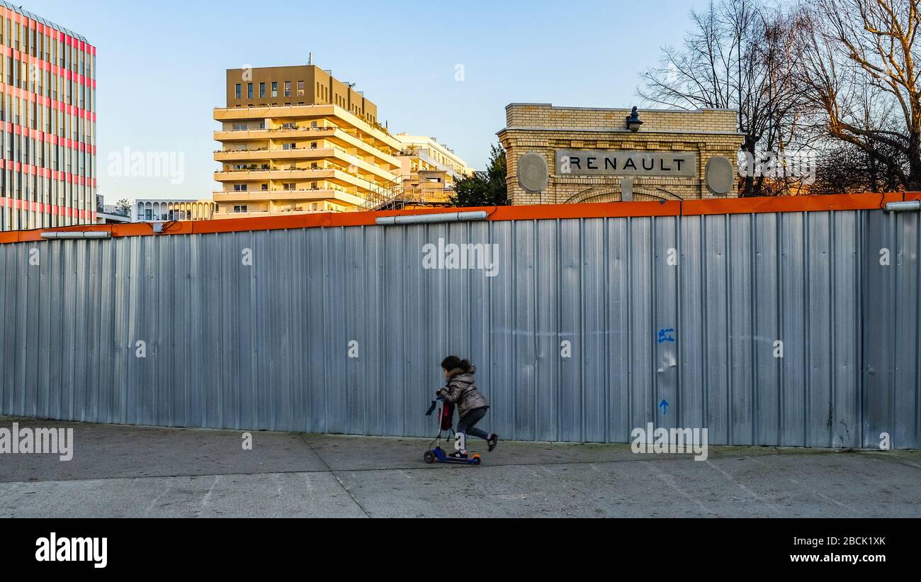Il vecchio muro della Renault a Boulogne Billancourt e un bambino che passa con uno scooter Foto Stock