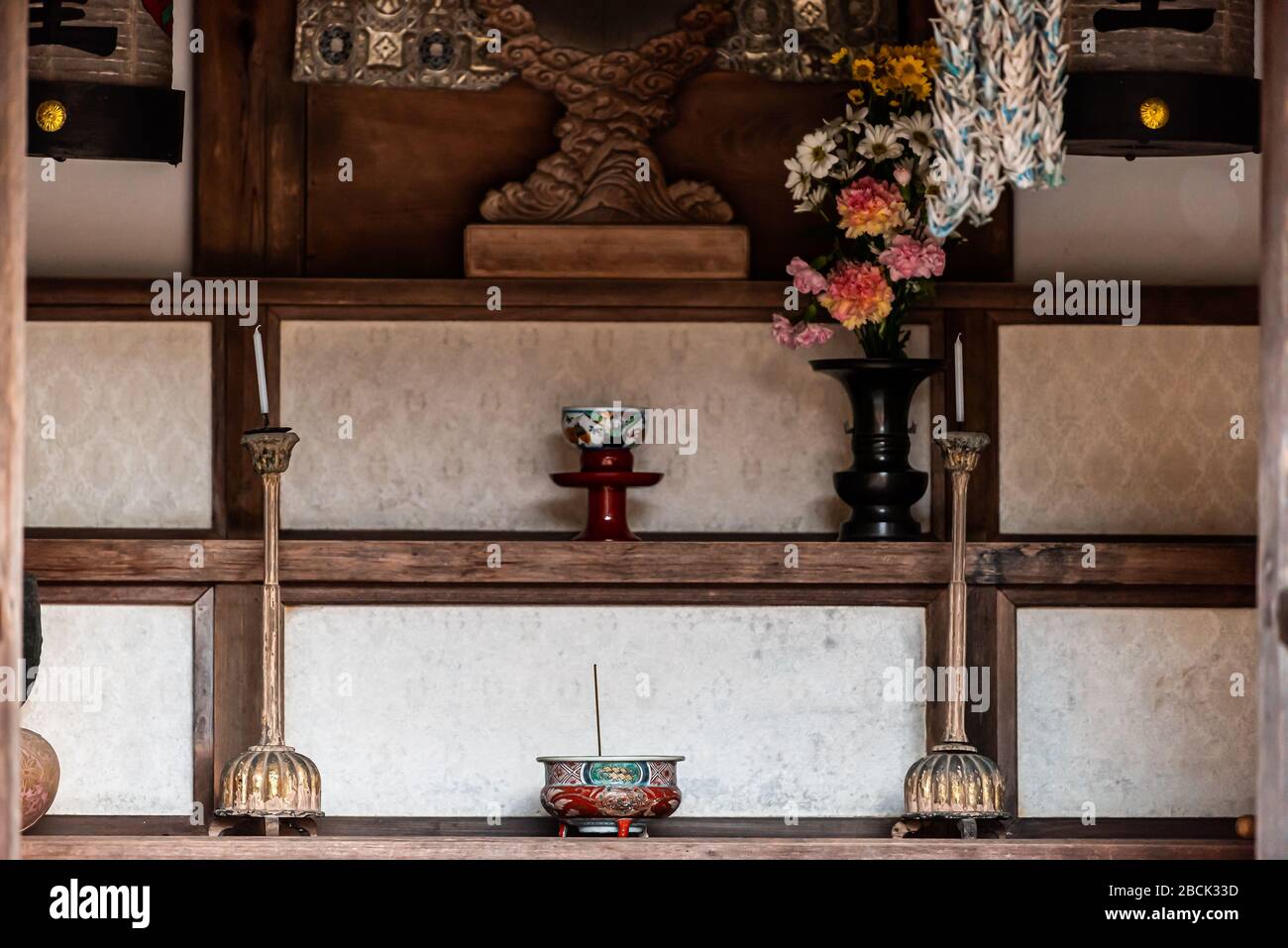 Shinto santuario con bastoni incenso in ciotola di sabbia con candele su candelieri e fiori in vaso a Higashiyama corso di cammino tempio santuario a Taka Foto Stock