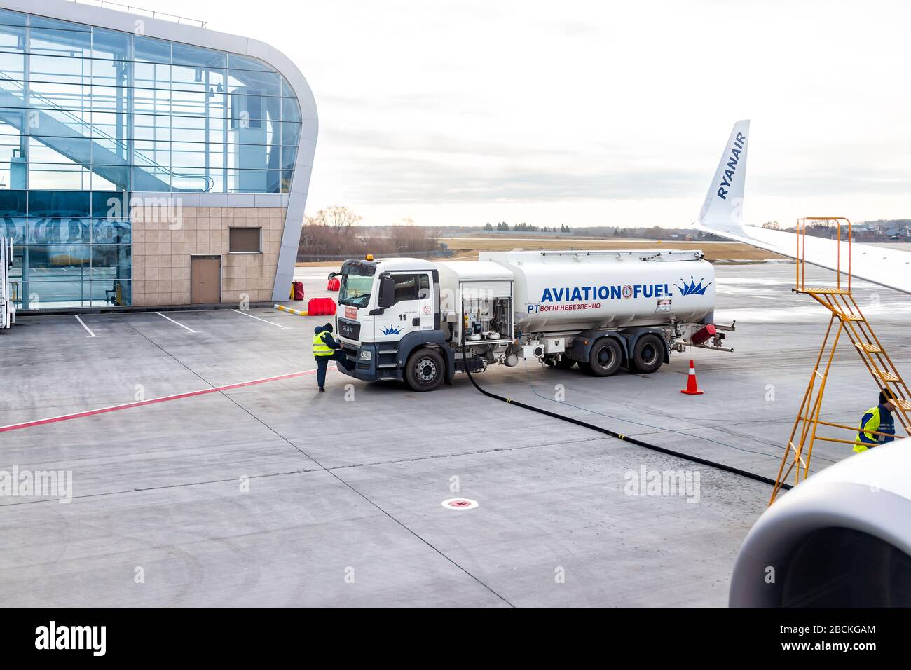 Lviv, Ucraina - 22 gennaio 2020: Esterno dell'edificio aeroportuale a basso costo a Lvov con i lavoratori che alimentano l'aereo Ryanair nella città Ucraina Foto Stock