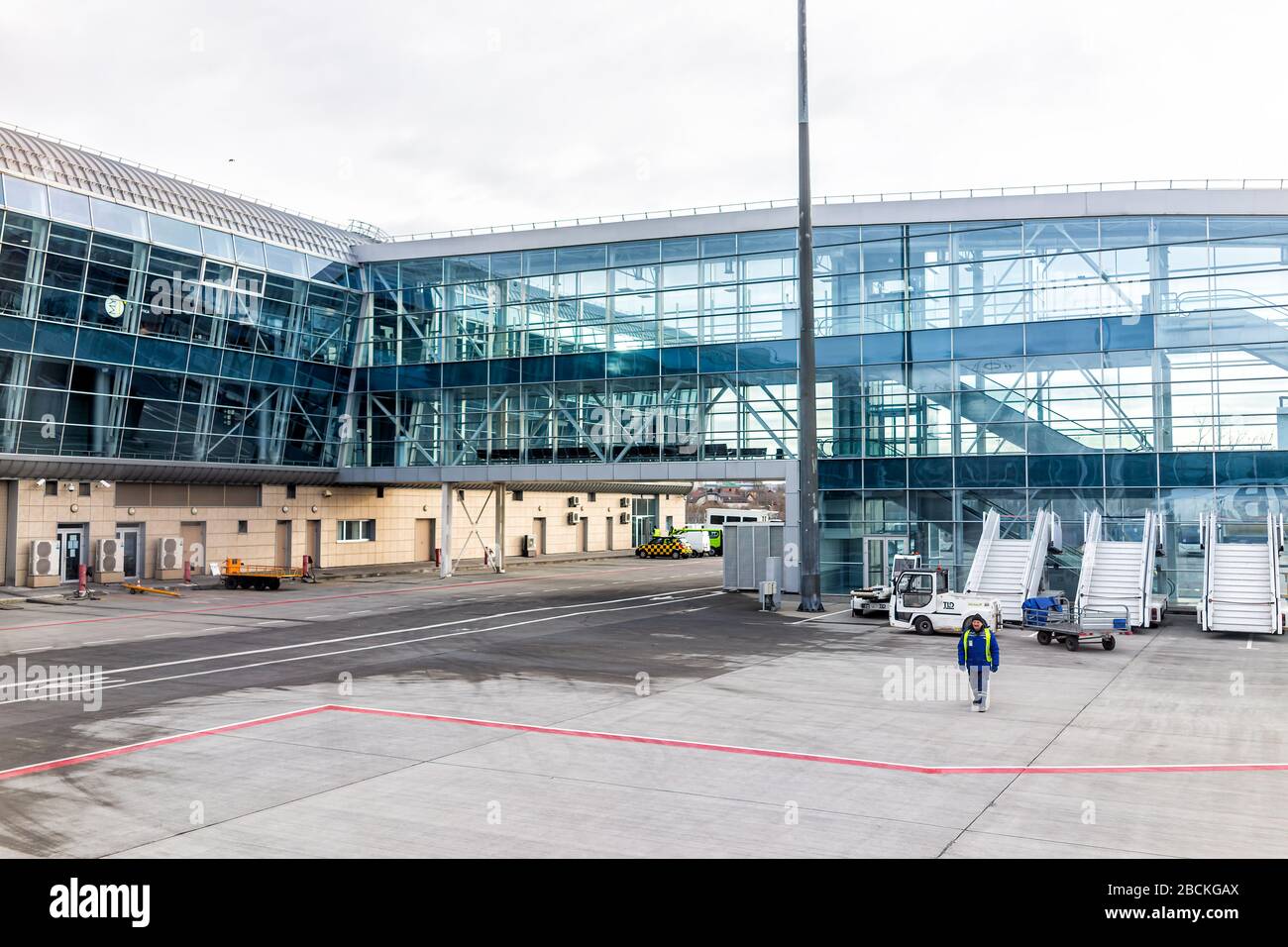Lviv, Ucraina - 22 Gennaio 2020: Esterno di un piccolo e moderno edificio aeroportuale a basso costo a Lvov con persone che camminano con trasporto concourse in Foto Stock