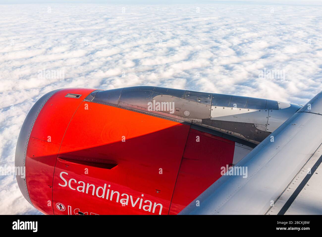 Varsavia, Polonia - 23 gennaio 2020: Motore aereo arancione in cielo con vista dalla finestra angolo alto e segno per Scandinavian Airlines sopra le nuvole Foto Stock